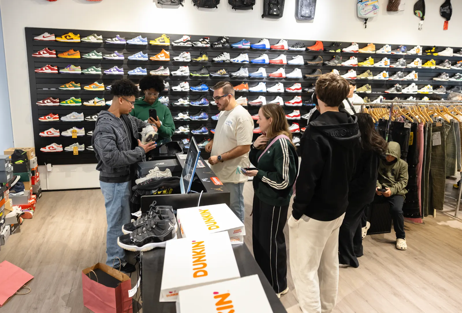 Sneaker wall and customers shopping at Soleinspires